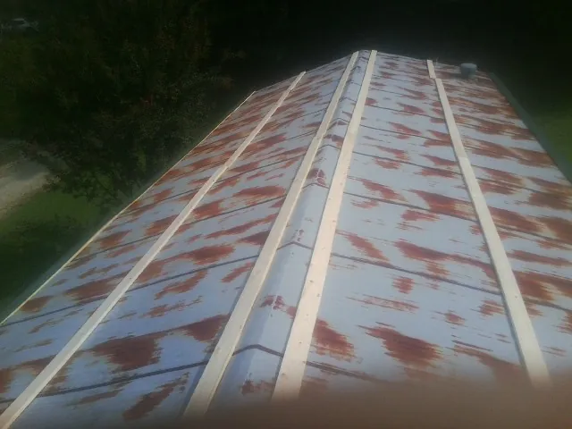 Rusted metal roof panels with new wood purlins before replacement — Storm Damage Roof Repair in Shaniko by Roofing Brothers
