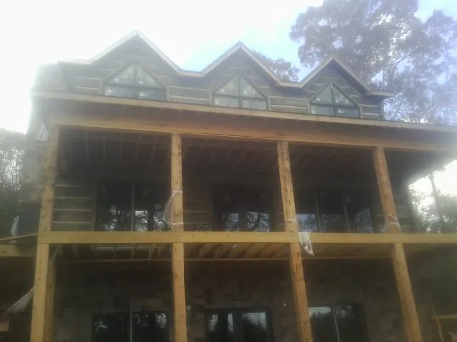 Dormers and porch framing on a large log home under construction — Roof Coating work by our crew in Shaniko