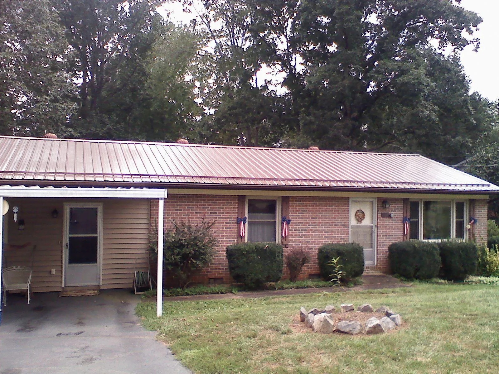 Bronze metal roof and carport on a brick ranch home — Roof Repair work by our crew in Shaniko